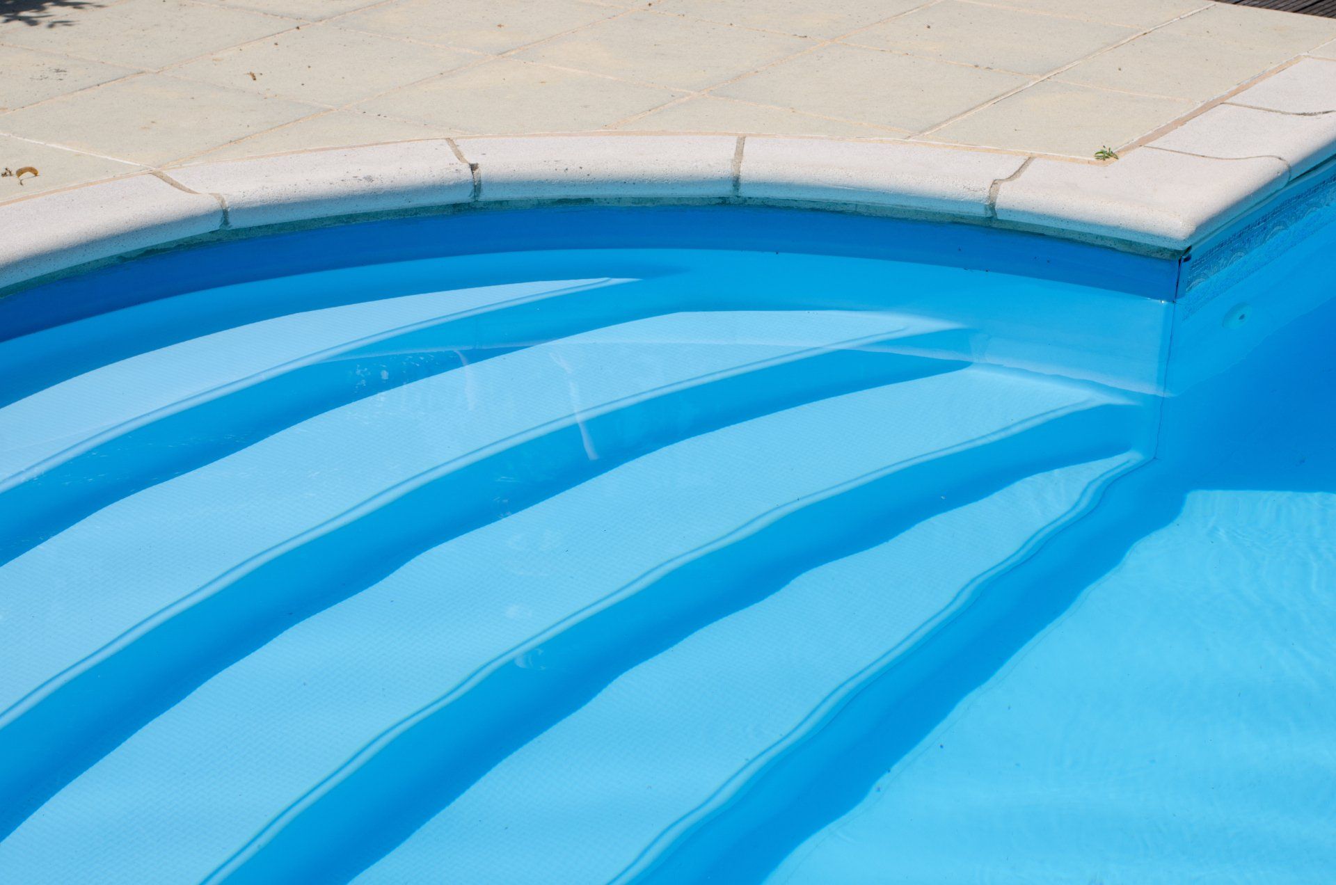 A close up of a swimming pool with blue steps